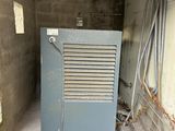 a small air conditioner sitting in the corner of a building