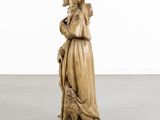 an image of a statue of a woman holding a dog