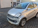 a small silver car parked on a cobblestone street