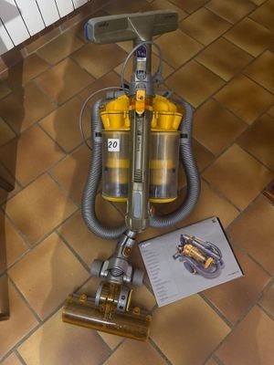 un aspirateur posé par terre à côté d'un livre
