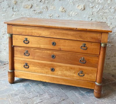 a small wooden chest of drawers on a brick floor