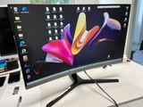 un écran d'ordinateur posé sur un bureau, à côté d'un téléphone portable