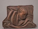 une petite plaque en bronze représentant une femme tenant une fleur