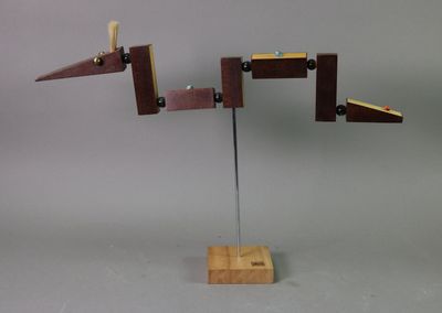 a sculpture made of wood and metal on a stand