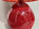 a red table lamp with a pink shade on it