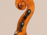 a close up of the back of a violin with a fiddle in the foreground