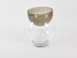 un vase en verre à bord doré posé sur une surface blanche