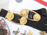 a black belt with gold buckles on a white table