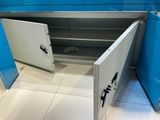 une armoire métallique dont la porte est ouverte, dans une pièce bleue