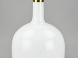 a white glass bottle with a gold metal handle and a light on top