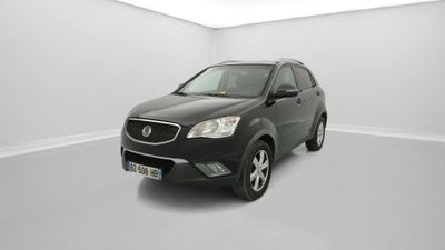 Une voiture noire est garée dans une pièce blanche au sol blanc.