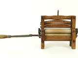 a small wooden machine with a roll of paper on it