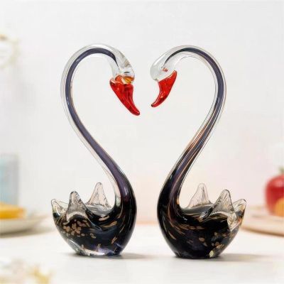 two glass swans making a heart shape with their necks