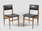pair of chairs with black leather upholstered seats and wooden legs