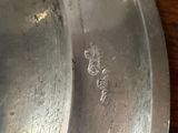 a metal pan on a wooden table with a handle