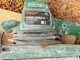 une machine verte et noire posée par terre