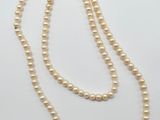 un collier de perles blanches avec un fermoir en or
