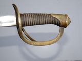 a close up of a sword with a gold handle on a white background