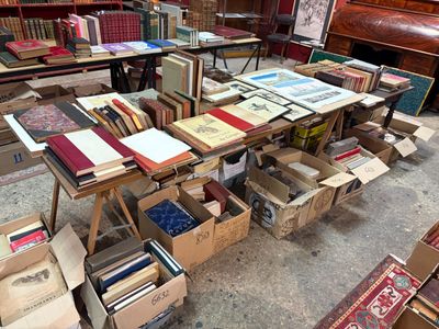 de nombreuses caisses de livres posées sur une table dans une pièce