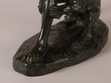 a statue of a man sitting on a rock with a dog