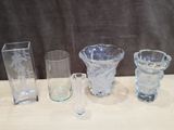 plusieurs vases et verres en verre posés sur une table devant un fond noir