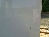 a white refrigerator sitting on a pallet in a parking lot