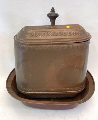 un plat marron muni d'un couvercle et sur lequel est posée une assiette