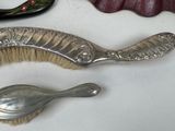 a silver brush and a silver spoon on a table