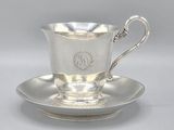 a silver cup and saucer on a saucer on a saucer
