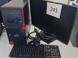 un ordinateur de bureau posé sur un bureau, à côté d'un clavier et d'un écran