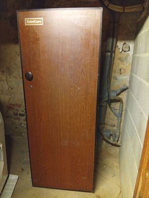 a wooden door in the corner of a room next to a toilet