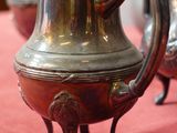 trois vases en argent posés sur une nappe rouge