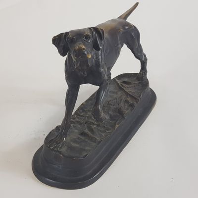 statue représentant un chien debout sur une planche de surf, posée sur un fond blanc