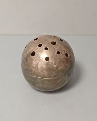 un petit objet métallique percé de trous