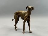 bronze statue of a dog standing on a white surface