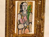 a painting of a woman holding a flower in a gold frame