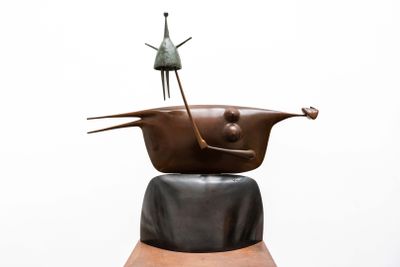 a sculpture of a woman sitting on top of a pot