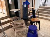 Plusieurs chaises et tabourets sont exposés dans une pièce