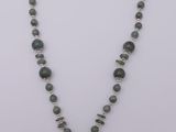 un collier orné d'une croix en perles de verre vertes