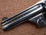an old revolver laying on a carpeted floor with a wooden handle