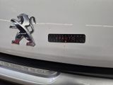 a white car with a lion emblem on the front of it