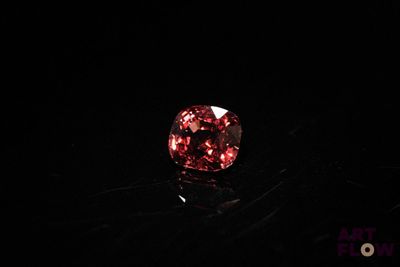 a close up of a red diamond on a black surface