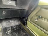 l'intérieur d'une voiture verte équipée d'un tapis de sol noir