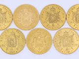 six types différents de pièces d'or sur une surface blanche