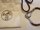 un gros plan sur un sac muni d'un porte-clés et d'une lanière