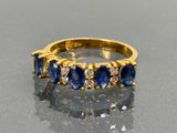 an image of a gold ring with blue sapphires and diamonds