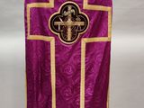 a close up of a purple and gold vest with a cross on it