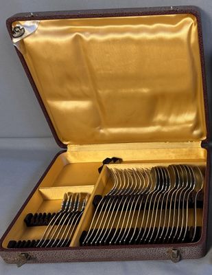 une mallette marron contenant des couverts, posée sur une table