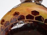 a close up of a vase on a white surface