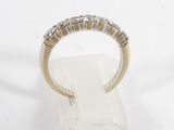 a close up of a diamond ring on a stand on a white surface